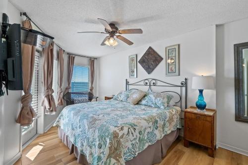 een slaapkamer met een bed en een plafondventilator bij Boardwalk 783 in Gulf Shores