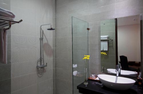 a bathroom with a glass shower and a sink at The Visala Boutique Suites Seminyak in Seminyak