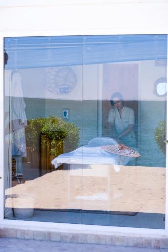 a reflection of a woman in a glass window at La Crique Nature & Spa in Dakhla