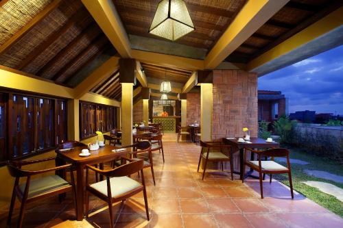 a restaurant with tables and chairs on a patio at The Visala Boutique Suites Seminyak in Seminyak