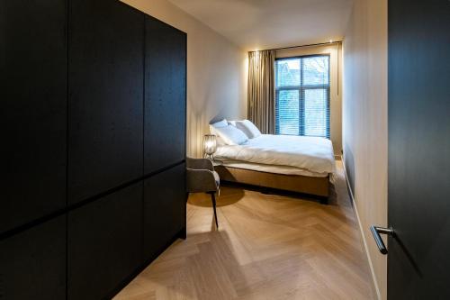 een kleine slaapkamer met een bed en een raam bij Breda City Apartments in Breda