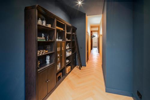 a hallway with a large wooden cabinet filled with shoes at Breda City Apartments in Breda
