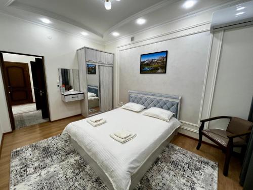 1 dormitorio con 1 cama y 1 silla en Renovated apt by the Savitsky Museum, en Nukus