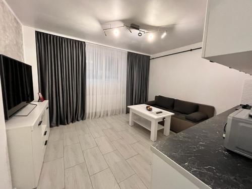 a living room with a couch and a television at White & Elegant Luxury Apartament Decomandat in Craiova