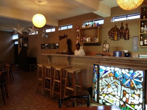 a man sitting at a bar in a restaurant at Ikweta Country Inn Maua in Kaathene