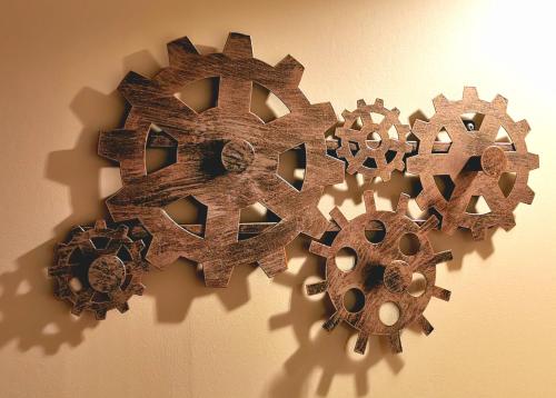 three wooden gears are hanging on a wall at Le Vieux Tacot avec garage in Le Puy en Velay