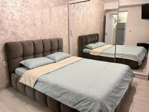克拉約瓦的住宿－White & Elegant Luxury Apartament Decomandat，一间卧室配有两张床和镜子