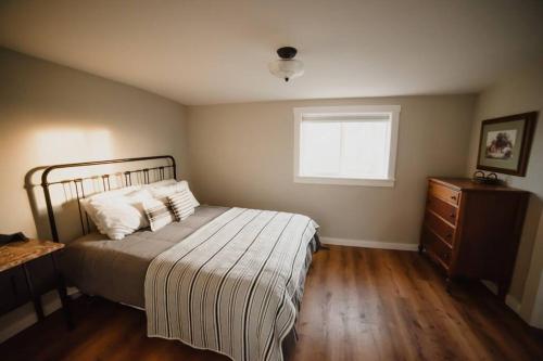 a bedroom with a bed and a dresser and a window at The Heritage House in Klamath Falls