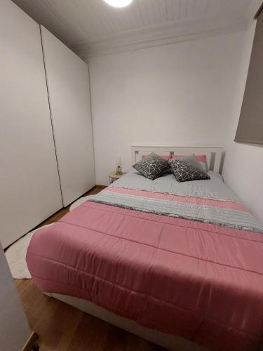 a bedroom with a large pink bed with two pillows at Casa Vale do Rio in Penacova