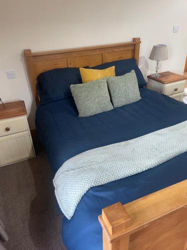 Una cama con sábanas azules y almohadas en un dormitorio en The Berkeley en Peopleton