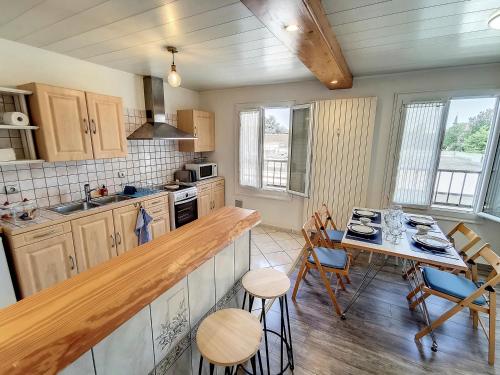 a kitchen with a counter and a table with chairs at Grand appartement Les Peintures in Thonon-les-Bains