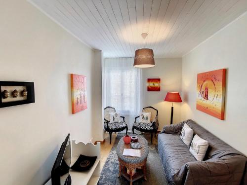 a living room with a couch and a table at Grand appartement Les Peintures in Thonon-les-Bains