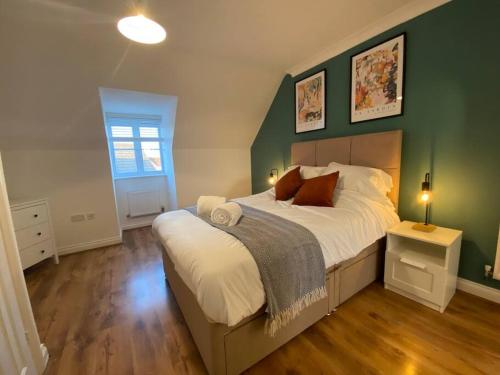 1 dormitorio con 1 cama grande y paredes verdes en Stylish 3-Bed House with Free Parking & Netflix by HP Accommodation, en Northampton
