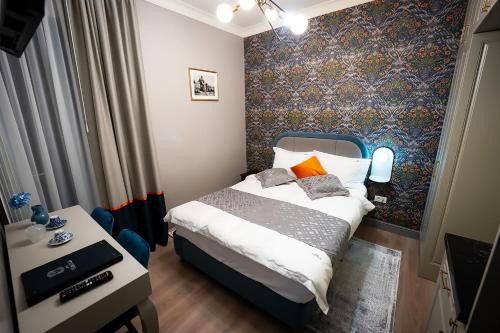 a small bedroom with a bed and a wall mural at Tempus in Bucharest