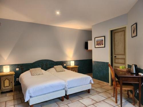 a hotel room with a bed and a desk and a desk at Domaine Les Gendalis in Saint-Saturnin-les-Avignon