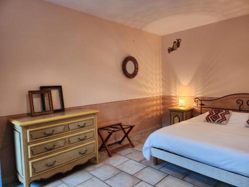 a bedroom with a bed and a dresser at Domaine Les Gendalis in Saint-Saturnin-les-Avignon