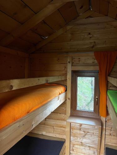 two bunk beds in a wooden cabin with a window at Ubytování na Horečky Ranči in Nový Jičín