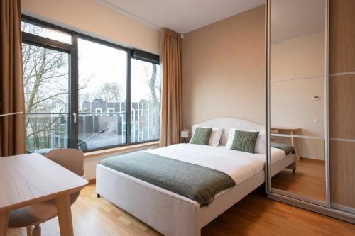 1 dormitorio con cama y ventana grande en 2 Bedroom Apt, 2 Garage Spots & Balconies, Self Check-in, by Cohost, en Druskininkai