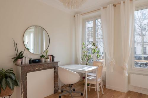 Cette chambre blanche dispose d'une table et d'un miroir. dans l'établissement Luxury cocoon in Paris 11th, à Paris
