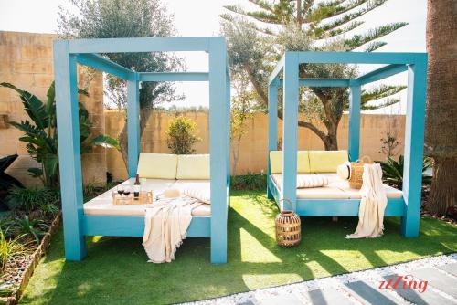 un gazebo blu con due letti in un cortile di Gozo Dream with Heated Indoor Pool and an Outdoor Pool a Għarb