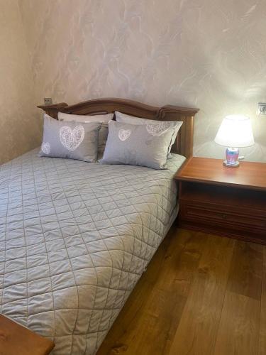 a bed with two pillows and a lamp on a table at Апартаменти на вулиці Залізняка - бічна вулиці Антоновича in Lviv