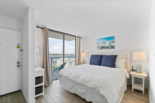 een witte slaapkamer met een bed en een balkon bij GS Surf & Racquet 516A in Gulf Shores
