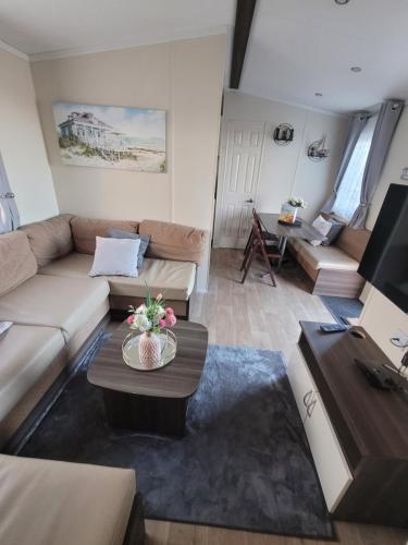 a living room with a couch and a table at 163 Holiday Resort Unity Brean - Centrally Located Pet Stays Free - Passes Included No Workers sorry in Brean