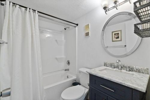 een badkamer met een toilet, een wastafel en een spiegel bij GS Surf & Racquet 516A in Gulf Shores