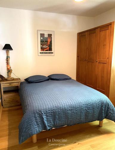 une chambre avec un lit avec une couette bleue dans l'établissement Maison bois flotté, à Lège-Cap-Ferret