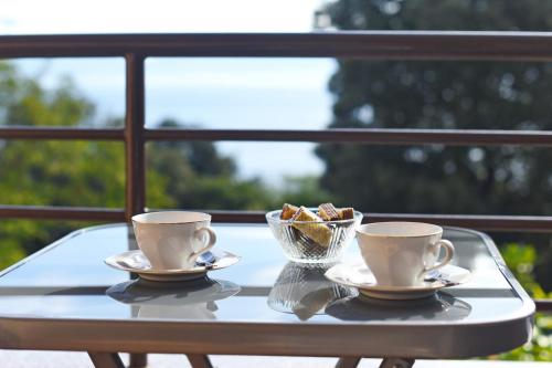 a table with two coffee cups and a bowl of bread at House ALANIS wtih sea view in quiet location in Ravni