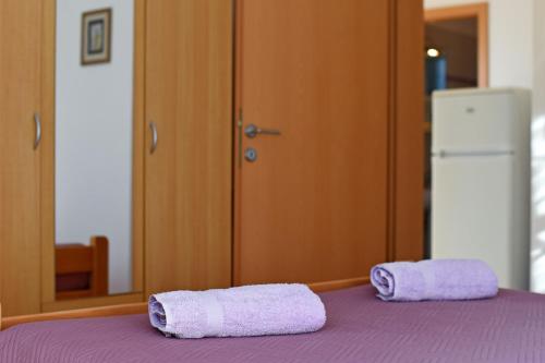 two towels sitting on top of a purple bed at House ALANIS wtih sea view in quiet location in Ravni