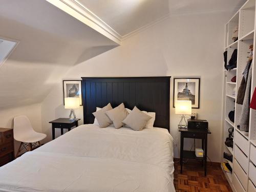 ein Schlafzimmer mit einem weißen Bett mit zwei Tischen und zwei Lampen in der Unterkunft Gran Piso en Viveiro con Parking Vista al mar in Viveiro
