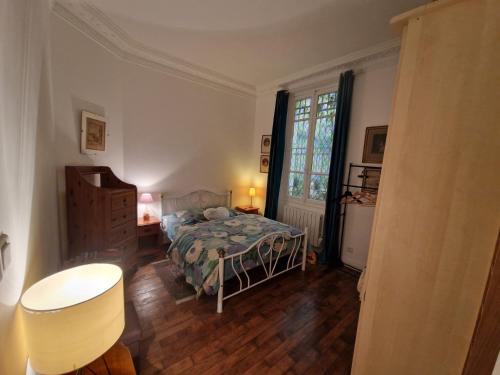 une chambre avec un lit, une table et une fenêtre dans l'établissement Appartement 2 pièces à Auteuil, à Paris
