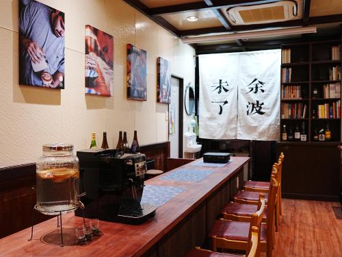 - un bar dans un restaurant avec un mur d'écriture dans l'établissement KOBE coffee hostel, à Kobe