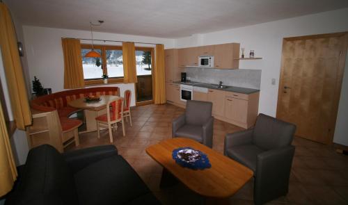 una cucina e un soggiorno con tavolo e sedie di Appartement Hochmuth a Ramsau im Zillertal