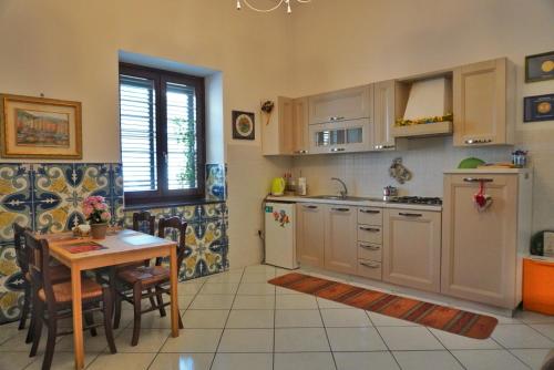 una cucina con tavolo, lavandino, tavolo e sedie di Todisco Apartament a Pompei