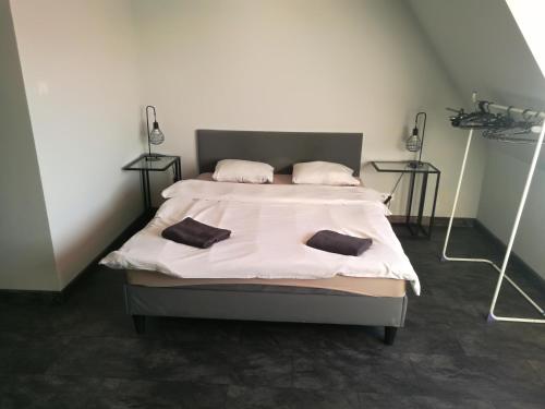 um quarto com uma cama com duas almofadas em Apartamenty Sielawa em Mikolajki