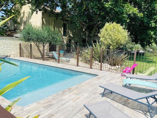 - une piscine avec 2 chaises longues à côté d'une maison dans l'établissement Mas de la Finière, à Châteaurenard