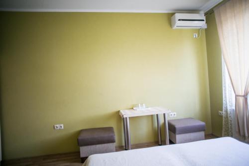 a room with a bed and a table and chairs at Tulipan Hotel Aquapark in Vyshkove