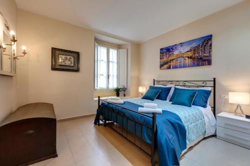 a bedroom with a bed with blue pillows at Golden House in Florence