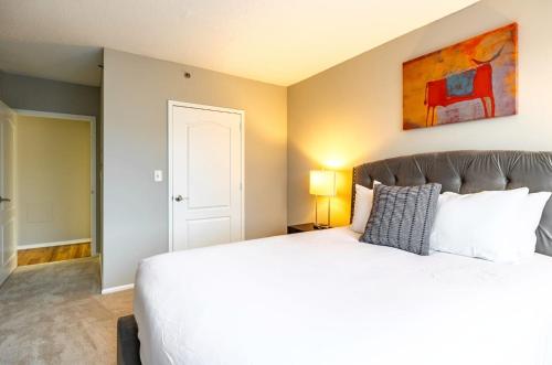 a bedroom with a large bed and a painting on the wall at Modern & Spcaious Apt Near Downtown in White Plains