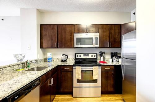 a kitchen with stainless steel appliances and wooden cabinets at Modern & Spcaious Apt Near Downtown in White Plains