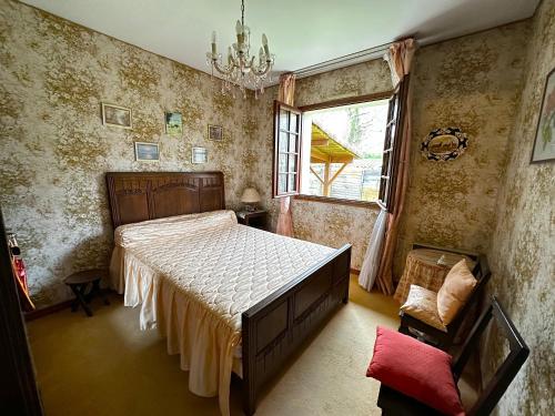 een slaapkamer met een groot bed en een raam bij Maison dans la forêt in Gujan-Mestras