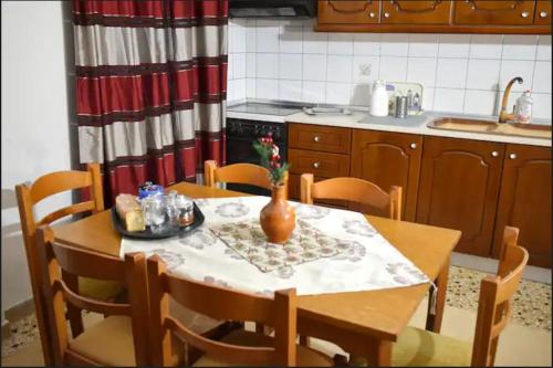una cocina con una mesa con un jarrón. en Little House, en Mouzákion