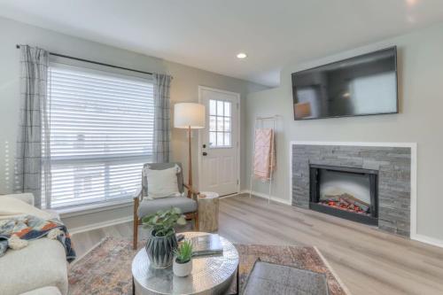 a living room with a fireplace and a tv at Walk to Broadway Riverfront Condo with Pool in Nashville