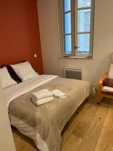 une chambre avec un grand lit avec des serviettes dessus dans l'établissement Centre historique rue Saint Guilhem, à Montpellier