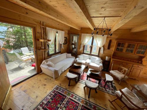un soggiorno con un divano e un tavolo di Fireplace Chalet a Žabljak
