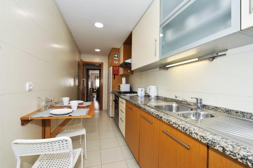 a kitchen with a sink and a counter top at Oeiras by the beach - Checkinhome in Oeiras