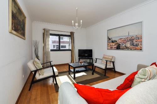 a living room with a couch and a table at Oeiras by the beach - Checkinhome in Oeiras