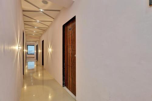 a hallway with a wooden door in a building at Vr Hotel in Surat